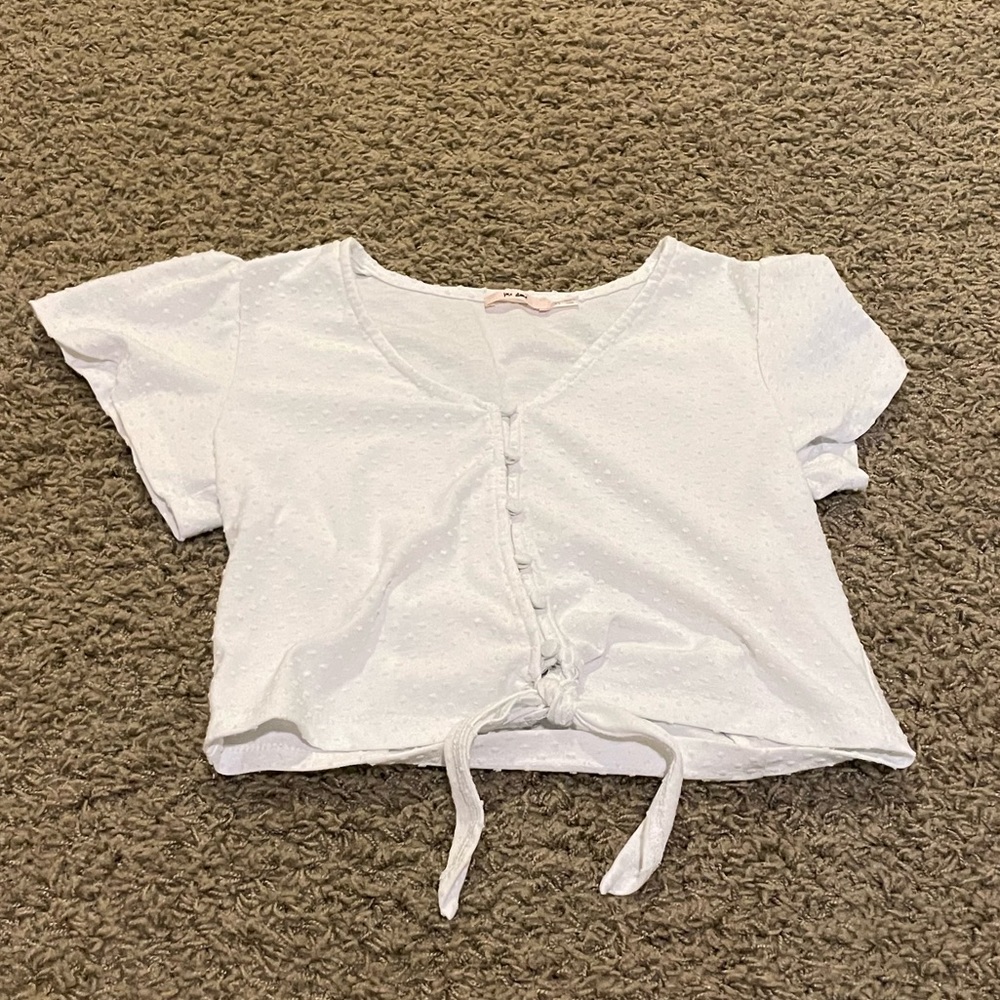 White t shirt with buttons and a tie at the bottom